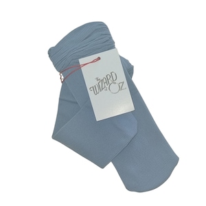 Op de afbeelding: Een paar lichtblauwe geribbelde sokken met een wit label waarop "The Wizard of Oz" staat.