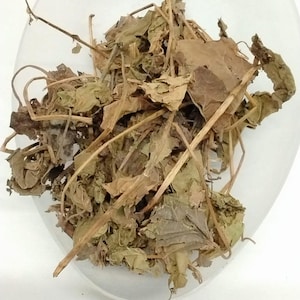 May include: A close-up view of dried leaves and stems, showcasing a mix of brown and green hues. The leaves appear to be in various states of dryness, with some curled and brittle. The image is set against a white background.