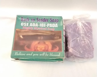 May include: A box of "Back to Sender Soap" with text in green and red. Next to it is a package of purple soap bars. The box reads "OSE ADA-IBI-PADA Highly Mystical Soap" and "Believe and you will be blessed."