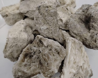 May include: A pile of rough, white, and gray rocks with some crystals visible. The rocks have a natural, earthy texture.