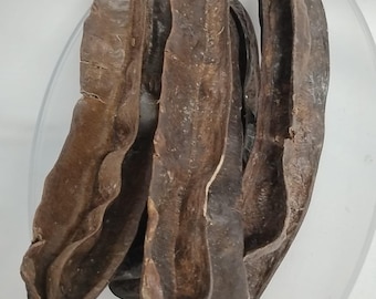 May include: Four brown carob pods, dried and ready to be used for cooking or baking.