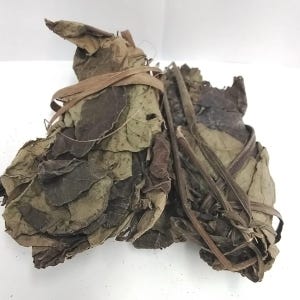 May include: Dried leaves, bundled and tied with natural fibers. The leaves display shades of brown and green, with visible veins and textures. The bundles are arranged against a white background, highlighting the natural colors and forms.