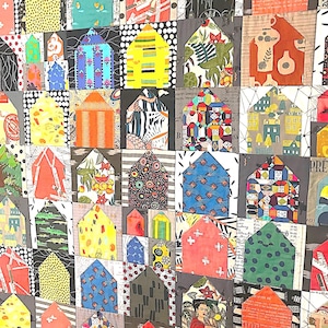 May include: A patchwork quilt featuring a grid of house-shaped fabric blocks. Each block displays a unique pattern, including floral, geometric, polka dot, and script prints in a vibrant color palette of red, yellow, blue, green, and black.