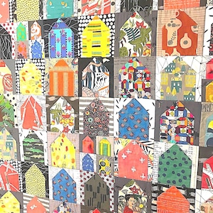 May include: A patchwork quilt featuring a grid of house-shaped fabric blocks. Each block displays a unique pattern, including floral, geometric, polka dot, and script prints in a vibrant color palette of orange, yellow, blue, green, and black.