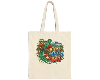 Pode incluir: Uma sacola de lona bege com uma ilustração colorida de um quetzal pousado em folhagem tropical com uma paisagem montanhosa ao fundo. O texto "I CROSSED AN OCEAN FOR THIS BIRD" está impresso em letras em negrito e estilizadas.