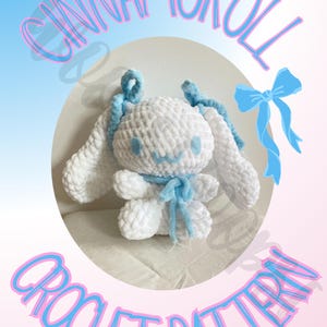 May include: Crochet pattern for a white Cinnamoroll plush toy with blue ribbon accents. The pattern is written in English and includes instructions for making the toy.