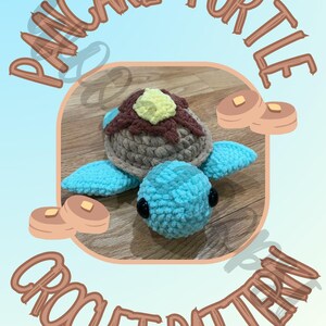 May include: A crocheted turtle toy with a pancake design. The turtle has a blue body, light brown shell, and a yellow butter-like topping. The image includes the text "PANCAKE TURTLE CROCHET PATTERN".