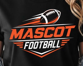 May include: A black t-shirt featuring a graphic design with an orange and white football in motion. The text MASCOT is printed in large orange letters above the word FOOTBALL in white, all set against a stylized orange and white background.