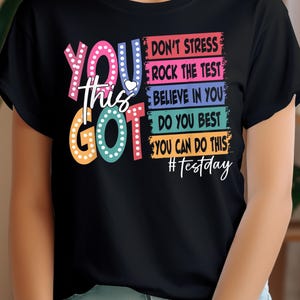 May include: Black t-shirt with a colorful graphic that says "You Got This" and includes the text "Don't Stress, Rock the Test, Believe in You, Do You Best, You Can Do This, #Testday".