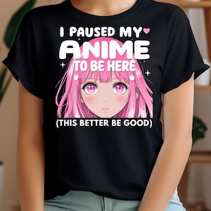 May include: Black t-shirt with a pink anime girl graphic and the text "I paused my anime to be here (this better be good)".