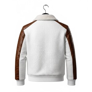 May include: White jacket with brown faux leather sleeves and accents, hanging on a black hanger. The jacket has a textured pattern on the white body and a fluffy white collar. The cuffs and hem are white.