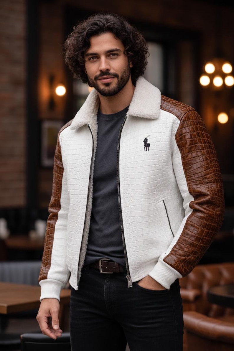 May include: White jacket with brown faux-leather sleeves and a faux-fur collar. The jacket features a black zipper, a small black logo on the chest, and a textured pattern. The jacket is paired with a dark gray shirt and black jeans.
