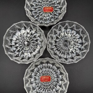 May include: Four clear crystal glass bowls with a starburst design. Each bowl has a diamond pattern and a red label that reads "GORHAM". The bowls are arranged on a dark surface.