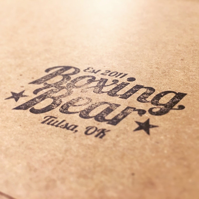 May include: A brown paper bag with a black and white logo that says "Boxing Bear" with the text "Est 2011" and "Tulsa, OK" underneath.
