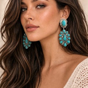 May include: Large turquoise and silver earrings. The earrings feature a cluster of turquoise stones in a floral design. The earrings are a statement piece, perfect for adding a pop of color to any outfit.