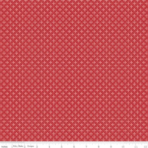 Op de afbeelding: Rode stof met een herhalend patroon van kleine vierkantjes en stippen. Het patroon is een lichtere tint rood dan de achtergrond. De stof is gemarkeerd met inches en de tekst "Riley Blake Designs".