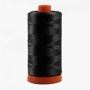 May include: A spool of black thread with an orange plastic bobbin.