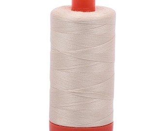 May include: A spool of beige thread with a bright orange top and bottom. The thread is tightly wound, creating a cylindrical shape. The image is against a white background.