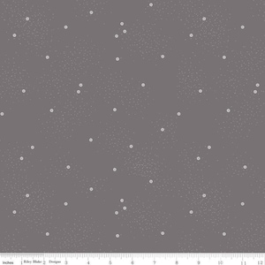 Puede incluir: Una tela con un fondo gris oscuro y un patrón de pequeños puntos blancos y grupos de puntos blancos. La tela se mide en pulgadas, con una regla a lo largo del borde inferior.