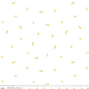 Könnte beinhalten: Weißer Stoff mit einem sich wiederholenden Muster aus kleinen gelben Zitronen mit grünen Blättern. Die Zitronen sind über die Oberfläche verstreut. Das Bild enthält ein Lineal in Zoll am unteren Rand.