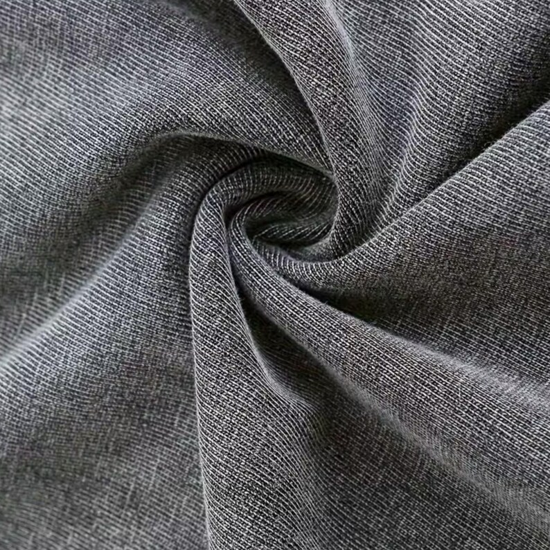 a close-up view of a wrinkled gray fabric, possibly denim or a similar type of material.