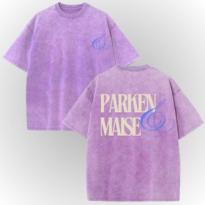 a purple t-shirt with the text "PARKEN & MAISE" printed on the back.