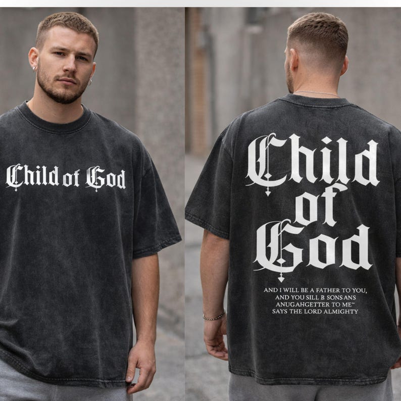 A man wearing a black t-shirt with the text "Child of God" printed on it, standing in front of a gray wall.