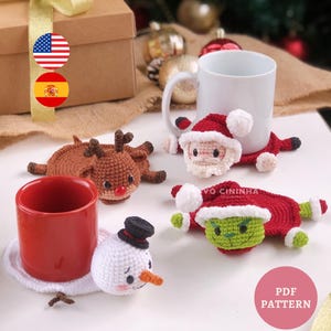 May include: A selection of crocheted Christmas-themed coasters, including a reindeer, Santa Claus, a snowman, and the Grinch. The coasters are in brown, red, white, and green. A red and a white mug are also present.