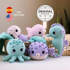 以下が含まれることがあります： パステルカラーの、手作りの編みぐるみ海の生き物コレクション。タコ、タツノオトシゴ、フグなど。おもちゃは編みかごの中に飾られています。画像には「PDF PATTERN」と「ORIGINAL DESIGN」という文字が含まれています。