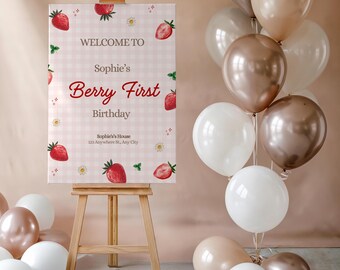May include: A pink and white gingham welcome sign with a strawberry theme. The sign says "Welcome to Sophie's Berry First Birthday" and includes a strawberry illustration and the address "Sophie's House, 123 Anywhere St., Any City".