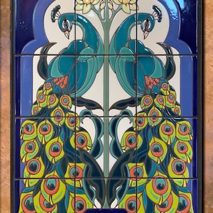May include: A ceramic tile mural depicting two peacocks with their tails spread out in a symmetrical pattern. The peacocks are blue, green, and yellow, and their tails are adorned with colorful eyes. The peacocks are standing on either side of a vase with white flowers. The background is a light blue color.