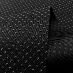 May include: Black fabric with a textured, dotted pattern. The fabric is folded over, showing the underside of the material.
