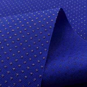 May include: Close-up of a blue fabric with a textured surface. The fabric has small, raised dots that create a subtle pattern.