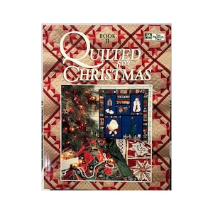 May include: A book titled "Quilted for Christmas" with a festive design. The cover features a Christmas tree, a quilt with holiday-themed squares, and a red and gold patterned background. The book is a Book II from That Patchwork Place.