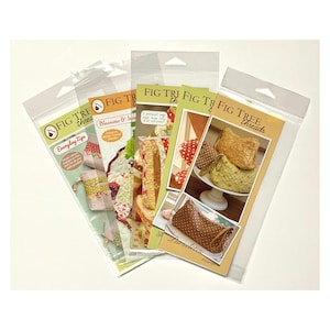 May include: A collection of five Fig Tree Threads sewing patterns packaged in clear plastic sleeves. Each pattern features instructional text and color photographs of finished fabric pouches, bags, and quilted items with various floral and polka dot prints.