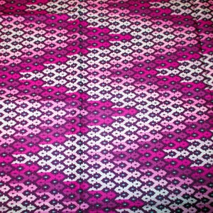 May include: A pink and purple fabric with a geometric pattern of small diamonds and squares.