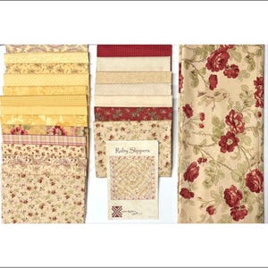 May include: A collection of fabric squares and a larger piece of fabric featuring a floral pattern with red roses and green leaves on a cream background. A paper pattern booklet titled Ruby Slippers is included, showing a quilt design.