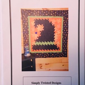 May include: A quilt pattern for a Halloween witch hat. The pattern is called "Halloween Twist" and is by Simply Twisted Designs. The phone number is (502)222-1044.