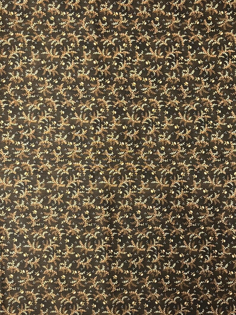 May include: Dark brown fabric with a repeating pattern of small, stylized floral and leaf motifs in shades of tan and off-white. The design creates a dense, all-over texture, suitable for various craft and sewing projects.