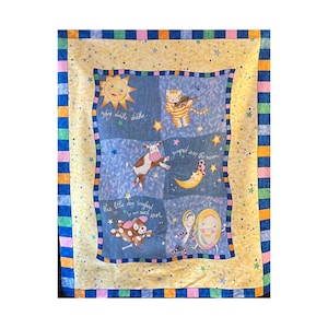 May include: A colorful children's quilt featuring a nursery rhyme theme. The quilt has a blue center with illustrations of a sun, cat, cow, moon, dog, dish, and spoon. The border is yellow with stars and a blue, pink, and orange striped edge.