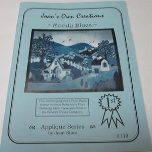 May include: A blue and white applique pattern for a wallhanging titled "Moody Blues" by Joan Statz. The pattern is part of the Applique Series and is number 110. The wallhanging won first place in Linda Meichee's Fiber Challenge in 1996.