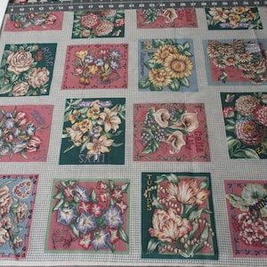 May include: A fabric panel featuring 12 different floral designs. Each square showcases a different flower, including roses, tulips, lilies, and sunflowers. The fabric is printed with a white background and green borders.
