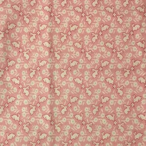 May include: Pink fabric with a repeating pattern of white bunnies and small white flowers.