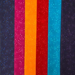 May include: A selection of fabric strips in vibrant colours, each adorned with a star design. The hues include navy, magenta, orange, red, teal, and dark purple. The stars vary in size and colour, creating a celestial theme.