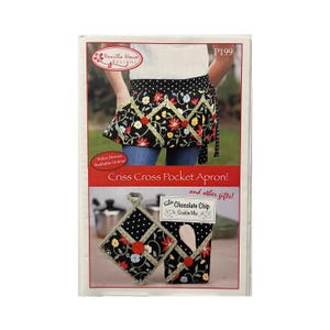 May include: A package featuring a black Criss Cross Pocket Apron with a floral design, a matching pot holder, and a cookie mix. The apron has a black background with red, yellow, and blue flowers. The text "Criss Cross Pocket Apron!" is visible.