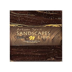 May include: A stack of fabric squares with a brown and gold metallic design. The fabric is labeled "Artisan Spirit SANDSCAPES CHIPS" with the website address www.northcott.com. The fabric has a marbled appearance.