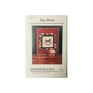 May include: A quilt pattern for a toy horse, featuring a red, white, and black color scheme. The pattern is titled "Toy Horse" and is from Thimbleberries, 205 Jefferson, Hutchinson, MN 55350.