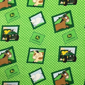 May include: Green fabric with a white polka dot pattern featuring framed illustrations of a brown horse, a cow, a white sheep, and a green tractor. The John Deere logo is also present.