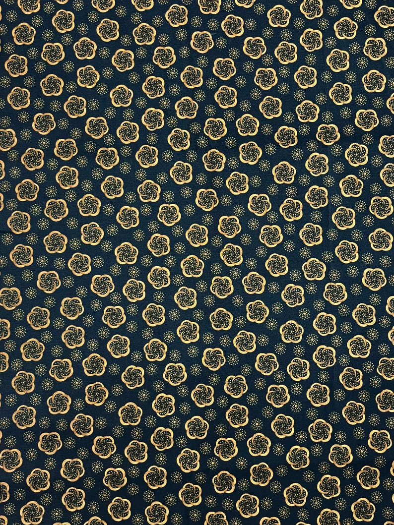 May include: Dark navy fabric with a repeating pattern of gold-colored floral designs and small gold dots. The floral pattern is a stylized, swirling design. The fabric has a dense, all-over pattern.