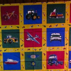 May include: A yellow fabric with a repeating pattern of various vehicles, including a car, truck, helicopter, airplane, and motorcycle. The vehicles are all in different colors and are surrounded by a yellow background with small, repeated images of tools.